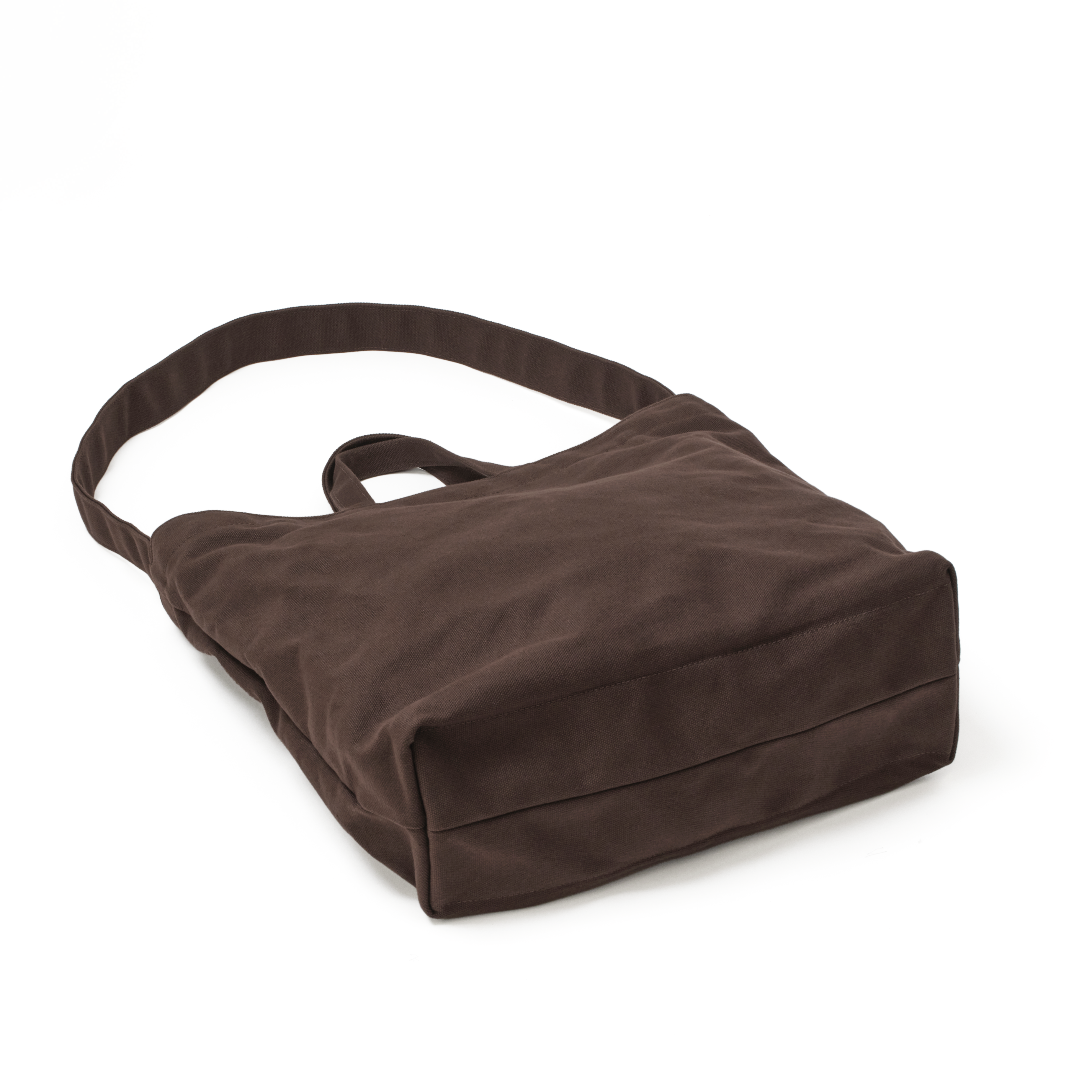 Angled back view of the MAKR Vert Sling Tote in Brown heavy cotton duck canvas.